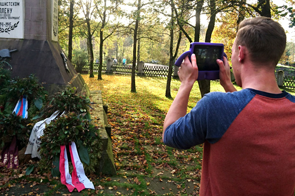 Ein Schüler des Berufskollegs Schloß Neuhaus filmt auf dem Sowjetischen Ehrenfriedhof in Schloß Holte-Stukenbrock mit einem iPad.