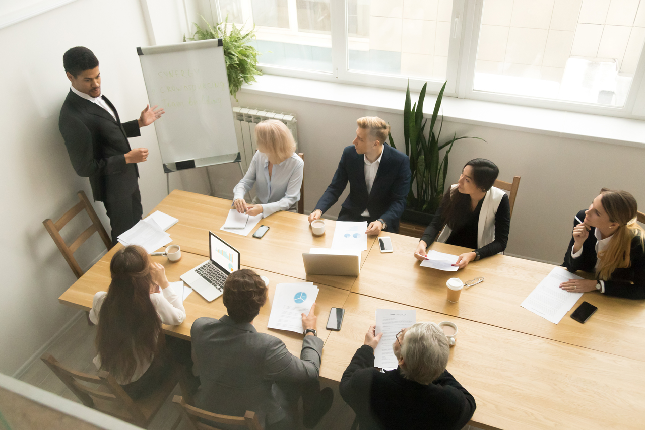 Gruppe sitzt am Tisch im Konferenzraum.